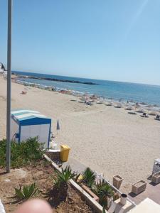 a beach with a blue tent and chairs and the ocean at studio avec piscine et wifi à cabonegro in Cabo Negro