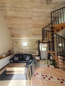 uma sala de estar com um sofá e uma escada em espiral em Penandaouent em Commana