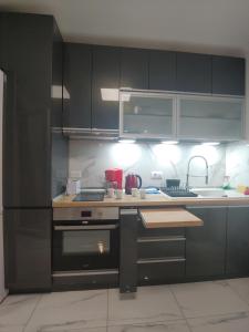 una cucina con armadi neri e piano di lavoro di New!90sqm10minAirport2bedrooms a Salonicco
