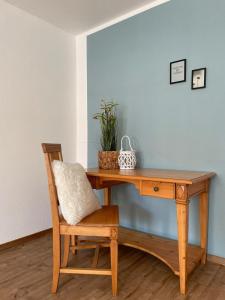 a wooden desk with a chair and a plant at Ferienhaus Janne in Monschau