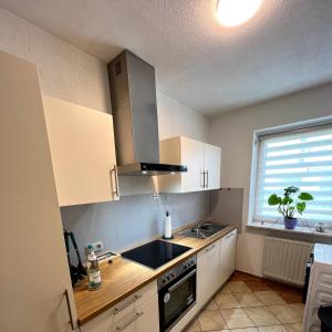 a kitchen with white cabinets and a sink and a window at Ferienwohnung Bautzen Süd in Bautzen