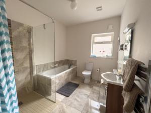 bagno con doccia, vasca e lavandino di Woodview Lodge a Trim