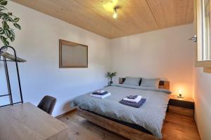 1 dormitorio con cama, mesa y espejo en B&B Bagnes, en Versegeres 