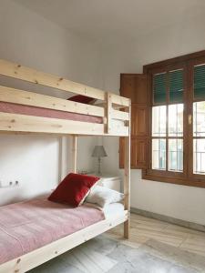 a bedroom with a bunk bed with a red pillow at Villa a los pies de la Alhambra in Granada