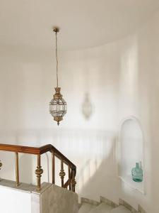 a stairway with a chandelier and a stair case at Villa a los pies de la Alhambra in Granada