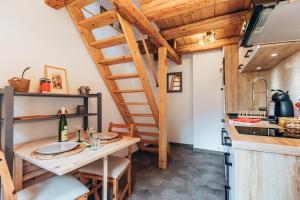a kitchen with a wooden table and a spiral staircase at Aux Cerfs des Vignes - L'annexe in Scherwiller