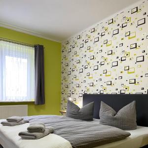 a bedroom with a large bed with a wall of squares at Ferienwohnung Bautzen Süd in Bautzen