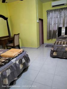 two beds in a room with green walls at Hotel Murah Pasir Puteh in Pasir Puteh