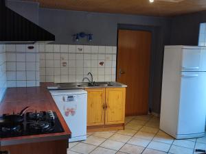 a kitchen with a stove and a white refrigerator at Chambre déplacement professionnel in Zilling