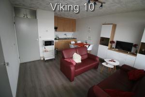 a living room with a red couch and a kitchen at Appartementen Zuiderstrand in Westkapelle