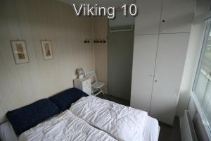 a bedroom with a white bed with blue pillows at Appartementen Zuiderstrand in Westkapelle