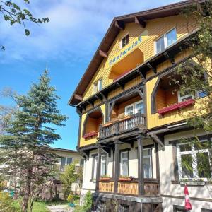 a large yellow building with a tree in front of it at Gasthof Edelweiss in Semmering