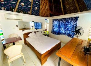 a bedroom with a bed and a desk and a table at Le BASTA in Ouagadougou