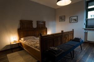 a bedroom with a wooden bed with a blue bench at "Ferienwohnung am Schloss" - Ferienwohnung mit Blick auf das Barbyer Schloss, 5 Gehminuten bis zur Elbe in Barby