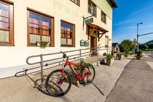 una bicicleta roja estacionada frente a un edificio en Gasthof Pichler en Grimmenstein