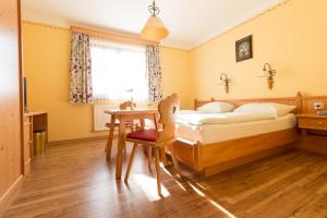 a bedroom with a bed and a desk and a table at Gasthof Pichler in Grimmenstein