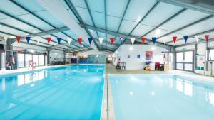 a large swimming pool with blue water at Fieldview 43 in Leysdown-on-Sea