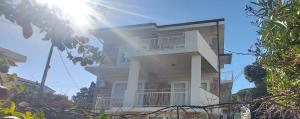 Appartamento 150 mq in villa sul mare a Fertilia في فيرتيليا: مبنى أبيض طويل مع الشمس في السماء