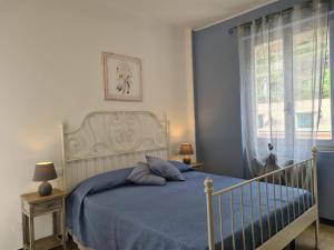 a bedroom with a bed with blue sheets and a window at Pippo a Vernazza Rooms in Vernazza