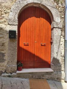 una puerta naranja con una maceta delante de ella en La Torre, en Santo Padre