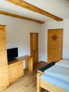 a bedroom with a bed and a desk with a tv at Ferienhotel Gut Enghagen in Rossleithen