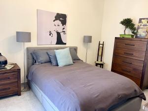 een slaapkamer met een bed en een schilderij aan de muur bij Ta Phyllis - Apartments & Villas with Sunset & Sea Views in Għajnsielem