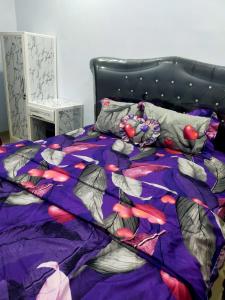ein Bett mit einer lila Bettdecke mit Fisch darauf in der Unterkunft azzima villa in Tlekung
