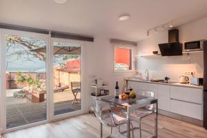 una cucina con tavolo e una cucina con patio di Papaya Cottage Punta del Hidalgo La Azócar a Punta del Hidalgo