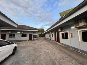 a car parked in a parking lot between two buildings at Metro Palace in Satun