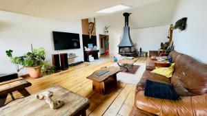a living room with a leather couch and a fireplace at Carwyns Surf House in Seignosse