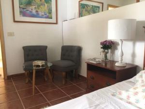 um quarto com 2 cadeiras, uma mesa e uma cama em Casa-solarium en la naturaleza em Santa Cruz de Tenerife