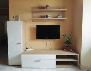 a white entertainment center with a television on a wall at Apartment Sara in Baška
