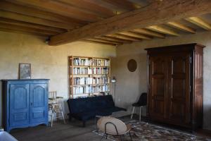 a living room with a blue couch and a book shelf at Maison ou chambres dans une belle ferme lauragaise 