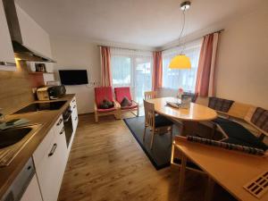 eine Küche und ein Wohnzimmer mit einem Tisch und einem Esszimmer in der Unterkunft Apart Zillertal in Aschau