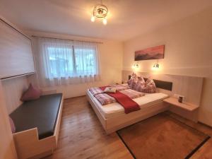 a small bedroom with a bed and a window at Apart Zillertal in Aschau