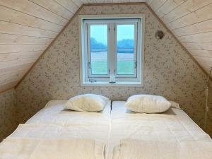 ein Bett mit zwei Kissen in einem Zimmer mit einem Fenster in der Unterkunft 5 person holiday home in Löderup-By Traum in Löderup