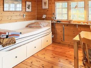 a bed in a room with wooden walls and wooden floors at Holiday home SEXDREGA in Sexdrega