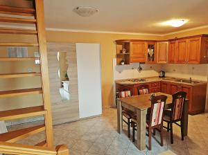a kitchen with a table and chairs and a staircase at Apartment Sara in Baška