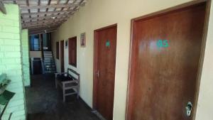an empty hallway with two wooden doors and a ladder at Pousada Flamboyan in Rio de Contas