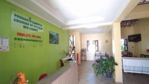 un hall avec un mur vert et des panneaux. dans l'établissement Pousada Flamboyan, à Rio de Contas