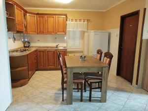 a kitchen with a table and chairs and a refrigerator at Apartment Sara in Baška +15 photos