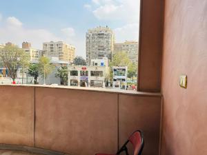 a person sitting on a ledge looking out a window at 100برج الثورة الدور 2 in Cairo