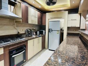 Il comprend une cuisine équipée d'un réfrigérateur et d'une cuisinière. four supérieur dans l'établissement 100برج الثورة الدور 2, au Caire
