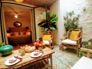 a room with a table and chairs and a bed at Romantic patio-house for 2 in the old centre in La Orotava