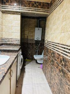 a bathroom with two sinks and a toilet in it at 100برج الثورة الدور 2 in Cairo