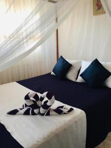 - une chambre avec 2 lits dotés d'oreillers bleus et blancs dans l'établissement Sun and Sand Apartment, à Ahangama