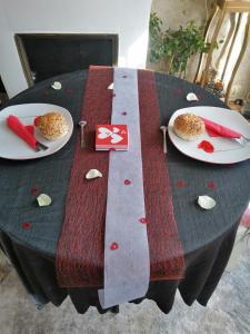 una mesa con dos platos de comida encima en Logement 2 Chambres Paradise Grand Jardin et Terrasse, en Férolles