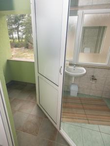 baño con lavabo y puerta de ducha acristalada en Guest House Maria, en Međugorje