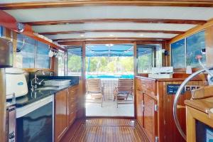 Una cocina con gabinetes de madera y un comedor. en Jambo die etwas andere Ferienwohnung am(im) Meer, en Rogoznica