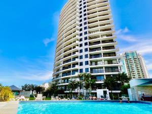 a large building with a swimming pool in front of a building at Oceanfront Family Apartment Pool & BBQ in Gold Coast